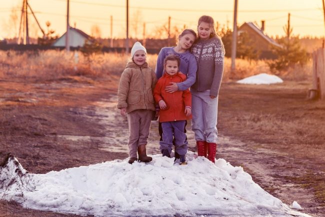 children play on the farm on a snowdrift