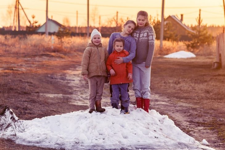 children play on the farm on a snowdrift