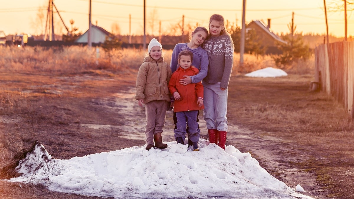 children play on the farm on a snowdrift